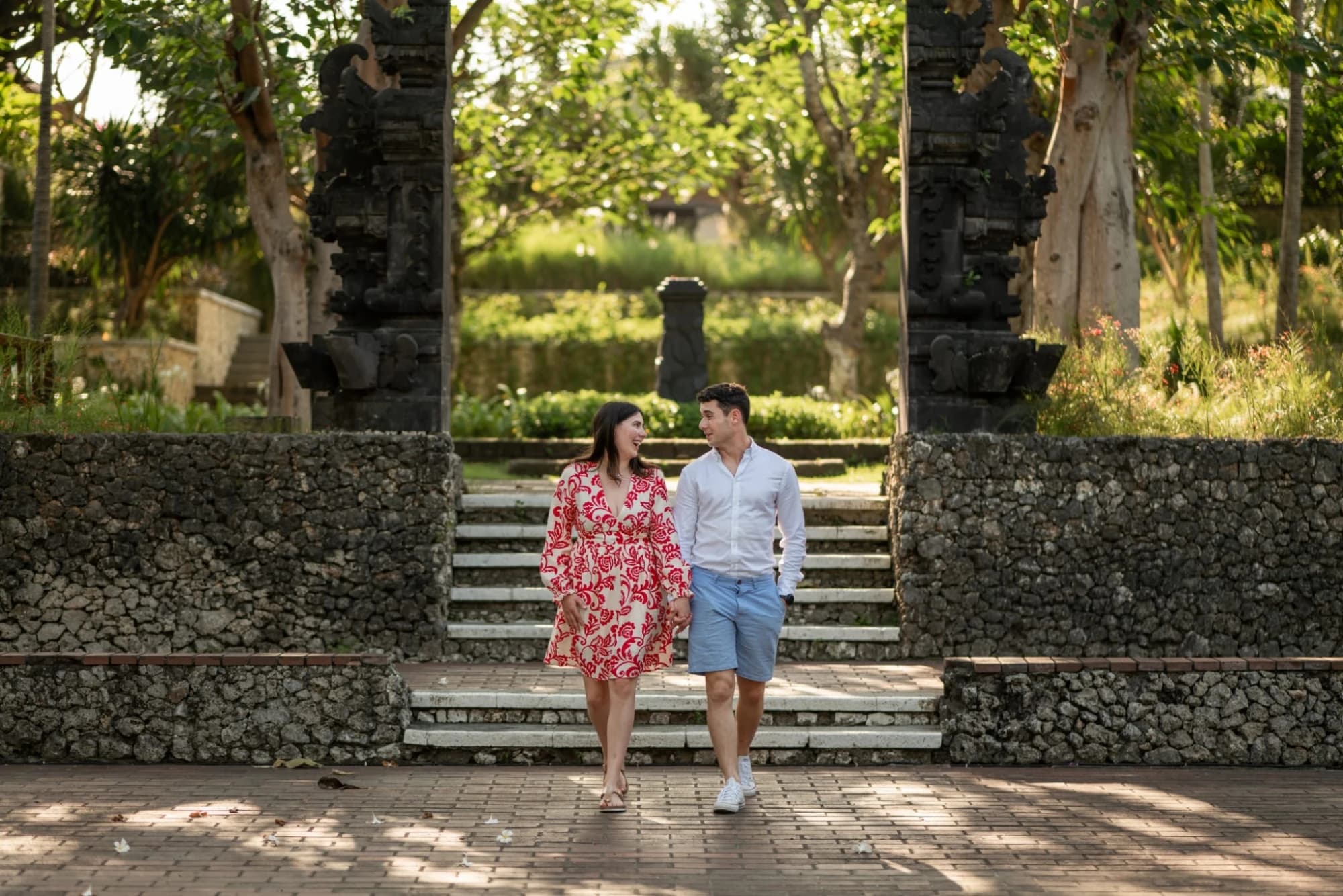Bríd and Barry walking hand in hand through a stone gateway
